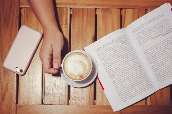 A photo of a book and a coffee.