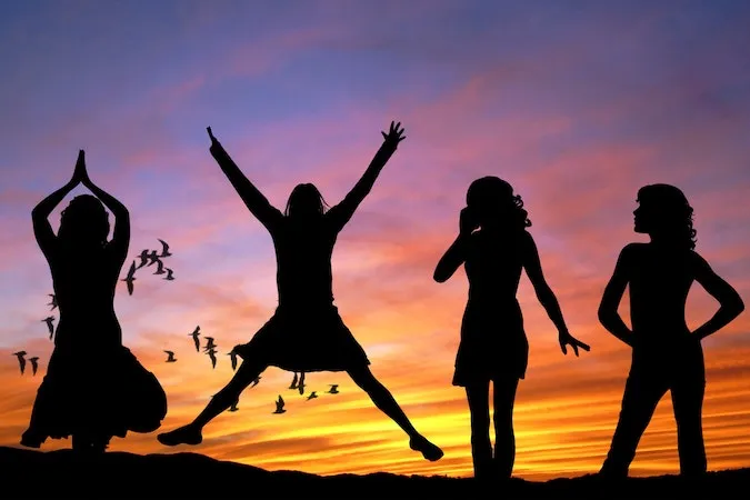 A photo of four silhouettes dancing.