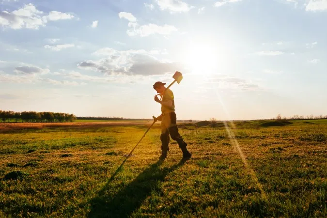 A photo of a man with a metal detector.